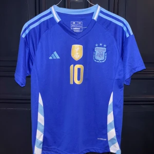 ARGENTINA KIT 24/25 - Säljer ett Argentina borta kit 24/25. Storlek 28 barnsize så ungefär 12-14 år. Messi och nummer 10 på ryggen shorts medkommer i storlek small! Hör av er för med frågor!