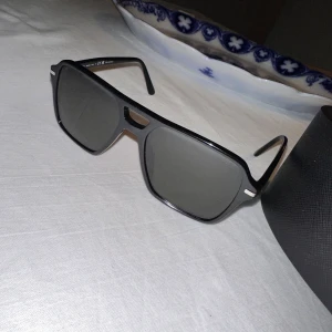 Prada solglasögon  -  Säljer Prada PR 20ys ”herr” solglasögon som är i nyskick, endast använd fåtal gånger. Solglasögonen är köpte på Blickpunkten i Femman för ca 2500 kr.