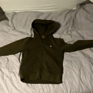 Grön huvtröja från Polo Ralph Lauren - Säljer en snygg grön huvtröja från Polo Ralph Lauren. Tröjan har en dragkedja framtill och en klassisk huva. Perfekt för en avslappnad stil. 🧥storlek 150, M i barn storlek