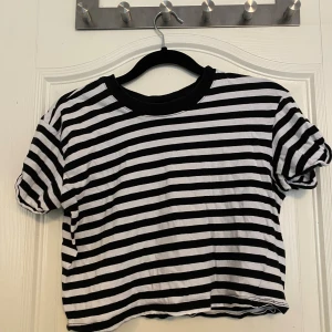 Randig kortärmad topp från H&M Divided - Säljer en svartvit randig topp från H&M Divided. Den har korta ärmar och en croppad passform. Använd ett fåtal gånger🌟 50kr