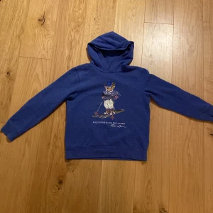 Blå hoodie från Ralph Lauren med Polo Bear - Säljer en tvär fet hoodie från Ralph Lauren med en polo bear på framsidan. Hoodie är I storlek S och i mycket bra skick. 