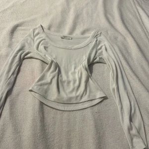 Vit ribbad topp från Chiquelle - Säljer en stilren vit ribbad topp från Chiquelle. Toppen har en rund halsringning och långa ärmar, perfekt för en chic och enkel look. Passar bra till både jeans och kjol. Hör av dig vid intresse!