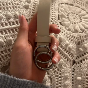 Vitt bälte med silverdetaljer ❤️ - Snyggt vitt bälte med en unik design av två silverringar som spänne. Perfekt för att ge en stilren touch till din outfit. Passar bra till både jeans och klänningar. Säljer då jag inte har användning  av det längre ❤️