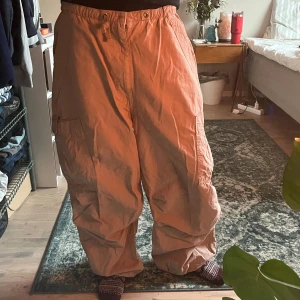 parachute byxor, jaded london - baggy beigea byxor från jaded london i storlek S. spännet i midjan är trasigt och de har även ett litet hål vid högra fickan, men annars är de i väldigt bra skick. 