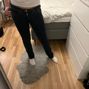 True religion jeans - Säljer mina mörkblåa true religions i storlek 28, med innerbenslängd 82 cm och midjemått rakt över 38 cm i bra skick. Modellen är Johnny (lite smalare bootcut)💞hör av dig vid funderingar 
