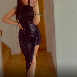 Svart glittrig klänning - Snygg svart glittrig klänning med en slits på sidan. Perfekt för en kväll ute eller en speciell tillställning. Klänningen är ärmlös och har en figurnära passform som framhäver silhuetten. Priset går att diskutera! Är lite osäker om storleken men skulle säga S