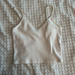 Beige ribbad linnetopp från Monki - Säljer en stilren beige ribbad linnetopp från Monki i storlek XS. Sälj för så billigt pris då den har en någon form av fläck på axelbanden, som dock inte syns särskilt mycket när man har på sig den (se på bild 4 & 5)💕