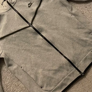 Grå nike tech från Nike - Använd fåtal gånger. Nypris 1000kr              Jag säljer den för att det inte längre är min stil. Storlek M. Köparen står för frakt🙂