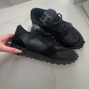 Svarta valentino rockrunners - Snygga svarta sneakers från Valentino med en stilren design. Skorna har snörning och är tillverkade i en kombination av skinn och mocka. Perfekta för en trendig look.