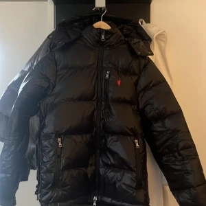 Svart dunjacka från Polo Ralph Lauren - Säljer nu min svarta Ralph lauren jacka då jag har har andra jag tycker bättre om. Använd cirka 2-3 gånger så den är så gott som ny. Original taggar ska finnas kvar så kan skickas med om så önskas. Storlek M. 