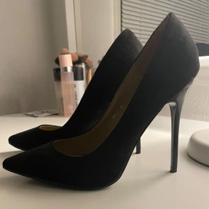 Svarta pumps med klack - Snygga svarta pumps med hög klack och spetsig tå. Endast använda ett fåtal gånger, bra skick!!