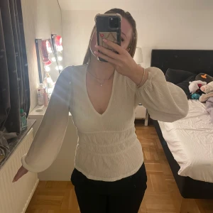 Vit v-ringad blus - Säljer en stilren vit blus med v-ringning och långa ärmar. Blusen har en smickrande passform med elastisk midja. Från Lindex storlek xs men passar s. Köpt för 350kr. Använd fåtal gånger därav inga defekter. Priset går att diskutera