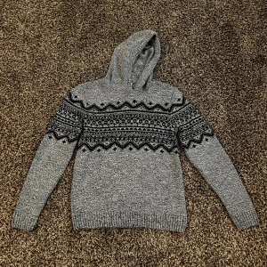 Stickad hoodie med mönster  - Extremt fet stickad hoodie med mönster som är lite tjockare jämfört med andra stickade hoodies vilket gör den både varm men även gör den lite snyggare. Storlek S med extremt bra passform. 