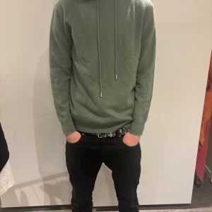 Grön cashmir - Säljer en stilren grön cashmir hoodie som är väldig eftertraktad och snygg! (100% cashmir) Aldrig använd helt ny! Storlek S passar dig mellan 175-184. Pris kan diskuteras vid snabb affär, inga skam bud!