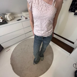 Ljusrosa spetslinne 💗💗 - Säljer ett ljusrosa spetslinne från Lindex i storlek 158/164.  Linnet har en oneshoulder-design med vackert blommigt spetsmönster och är super skön. Perfekt för en somrig look! 🌸