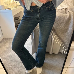 Blå bootcut jeans - Snygga blå bootcut jeans med medellåg midja. Perfekta för en avslappnad stil med en klassisk jeanslook. De har en dragkedja och knappar framtill samt fickor både fram och bak.💙 passar mig som är 170 cm