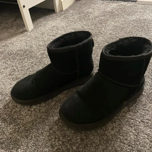 Svarta Uggs  - Säljer ett par svarta boots med mjukt foder. Perfekta för kyligare dagar med sin bekväma passform och värmande insida.