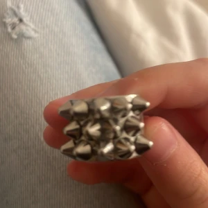 Silvrig ring med nitar - Cool och edgy silvrig ring med flera nitar i en unik design. Perfekt för att ge din outfit en tuff touch. Passar bra till både vardag och speciella tillfällen.