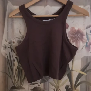 Brun ribbad linnetopp från lager 157 - Säljer en brun ribbad linnetopp från lager 157. Toppen är ärmlös och har en stilren design som passar perfekt för varma dagar.