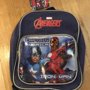 NY Avengers ryggsäck med Captain America och Iron Man - Liten Cool blå ryggsäck från Marvel med Avengers-tema. Framsidan pryds av Captain America och Iron Man. Perfekt för skolan eller utflykter. Ryggsäcken har justerbara axelremmar och ett stort huvudfack med dragkedja.