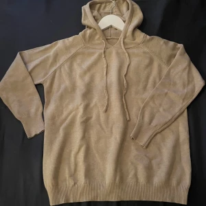 Beige merinoull hoodie - Säljer en stilren beige merinoull hoodie med långa ärmar och ribbade muddar. Perfekt för en avslappnad look. Har testat den en gång skulle testa storleken men den passa inte så jag säljer den.