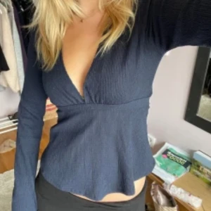 Mörkblå ribbad topp - Snygg mörkblå ribbad topp med v-ringning och långa ärmar. Helt oanvänd.☺️