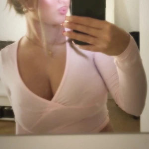 Rosa omlottopp - Snygg rosa omlottopp med lång ärm och v-ringad design. Perfekt för en stilren look.” Tryck inte på ” köp nu”