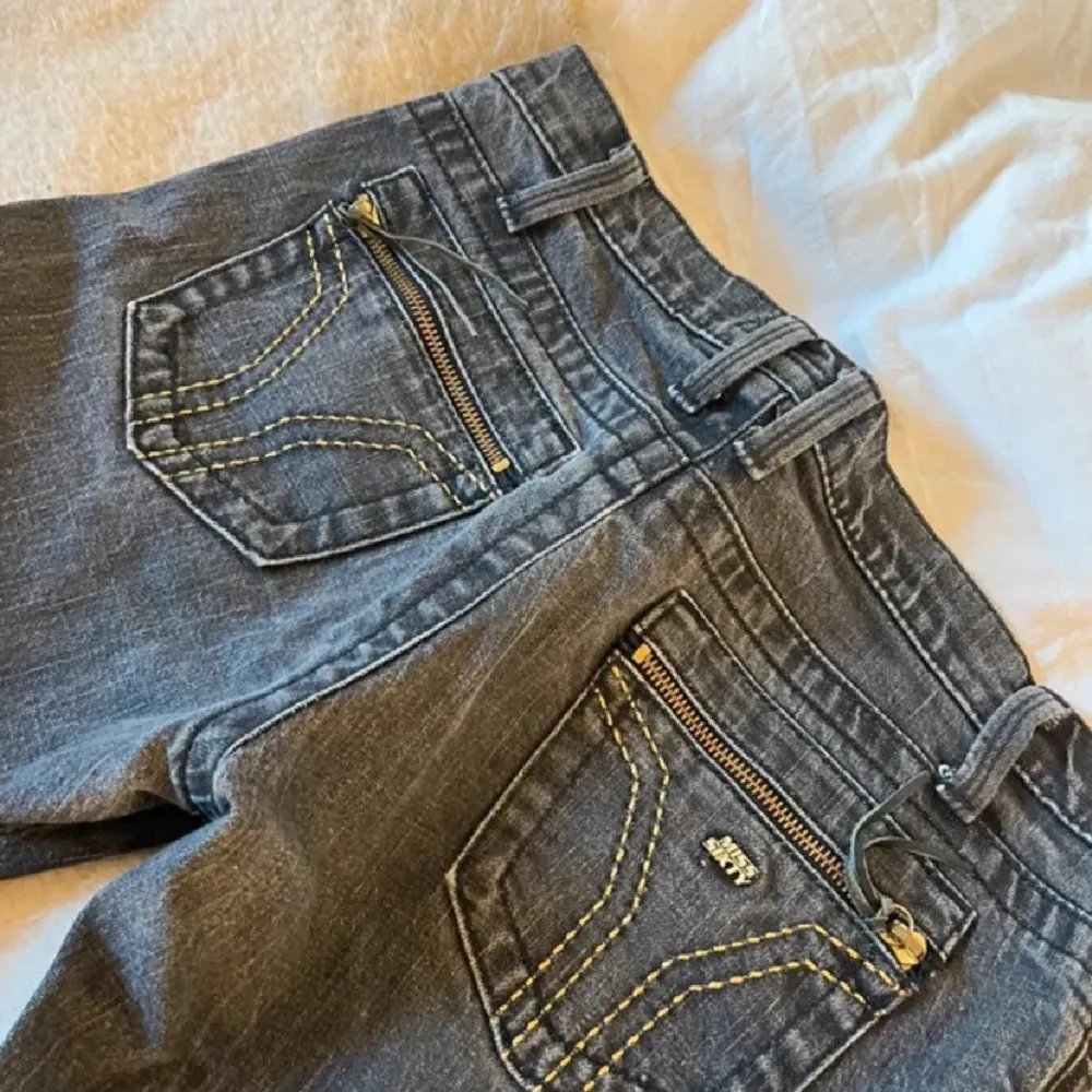 Snygga jeans från Miss Sixty med guldfärgade dragkedjor på bakfickorna. De har en klassisk femficksdesign och knappgylf. Perfekta för en stilren look.. Farkut & Housut.