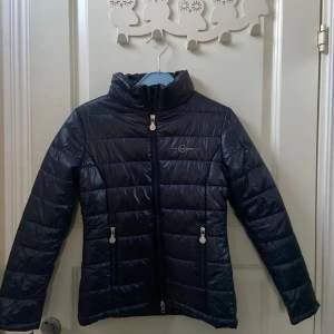Mörkblå pufferjacka från Covalliero - Säljer en snygg mörkblå  från Covalliero. Jackan har en hög krage och dragkedja framtill samt praktiska fickor med dragkedjor. Perfekt till stallet och ridning💕