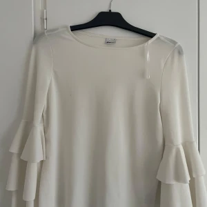 Vit tröja med volangärmar - Säljer en fin volangblus från Gina tricot i storlek S. Använd nån gång och ser helt ny ut. Kontakta vid intresse för kan sänka priset mer