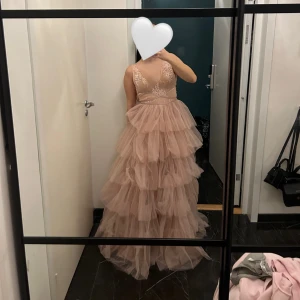 Balklänning/ aftonklänning - Balklänning/ aftonklänning/ festklänning. Färgen är mer ljus rosa än vad det ser ut på bilden. Köpt för ett par år sendan för cirka 5000 kr. Använd en gång. Storleken är en st 34-36.