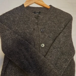 Kofta från lindex  - Mysig brun kofta från Lindex med knappar framtill. Perfekt för kyliga dagar med sin stickade design och ribbade detaljer vid hals och ärmslut.