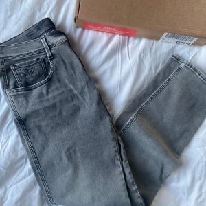 Grå Replay Hyperflex jeans - Snygga grå Replay Hyperflex jeans med en modern look. De har en klassisk femficksdesign och en bekväm passform. Perfekta för en stilren vardagsstil. OBS, helt oanvända direkt köpta från Replays hemsida. Storlek W32 L32