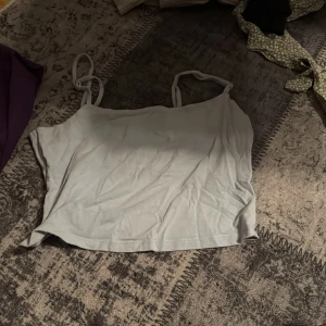 Ljusgrå linnetopp - Säljer en enkel och stilren ljusgrå linnetopp med smala axelband. Perfekt för varma dagar eller som ett basplagg i garderoben.