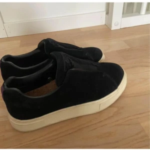 Svarta eytys - Snygga svarta sneakers med en lila remsa på baksidan och vit sula. Skorna har en stilren design och är perfekta för en avslappnad look🥰🥰