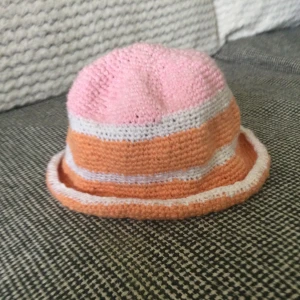 Virkad hatt i bomull - Virkad hatt i bomull Omkrets: 62 cm Höjd: 18-19 cm Vit/rosa/orange Oanvänd!
