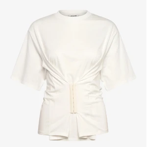 Vit t-shirt med knytning  - Snygg vit t-shirt från Monki med en unik knytning framtill som ger en stilren look. Den har korta ärmar och en rund halsringning. Den är slutsåld på hemsidan. Perfekt för en trendig och avslappnad stil. Säljer pågrund av att den är för liten på mig. 