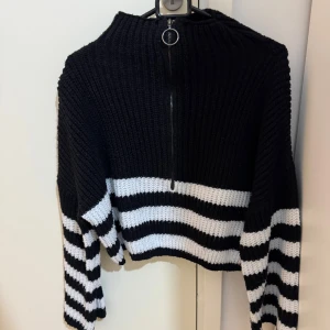 Svart och vit randig stickad tröja med dragkedja - En tröja i stl S som är i bra skick säljs för 80 kr. 