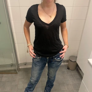 Svart v-ringad t-shirt - Säljer en stilren svart t-shirt med v-ringning. Perfekt för en avslappnad look. T-shirten har korta ärmar och är tillverkad i ett mjukt material. Lite genomskinlig vilket är väldigt snyggt och skönt💞💞den är knappt använd💞sååå fin!Den faller också väldigt fint vilket gör en bra passform!!