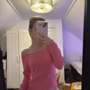 Rosa offshoulder topp från Bik Bok - Säljer en söt rosa offshoulder topp från Bik Bok. Toppen har långa ärmar och en ribbad design som ger en fin passform. Perfekt för en trendig look! Står att det är storlek M men hade rekommenderat för XS-S  om man vill kunna ha den off shoulder