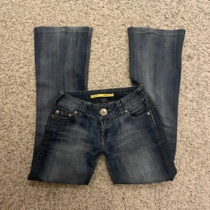 Mörkblå bootcut jeans - Snygga mörkblå bootcut jeans med klassisk femficksdesign och knappgylf. Perfekta för en avslappnad stil.