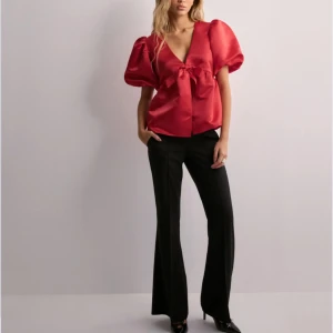 Röd blus från Nelly - Säljer en elegant röd blus från Nelly med puffiga kortärmar och en v-ringad design. Blusen har en knytning framtill. Helt ny, skriv för frågor ❤️