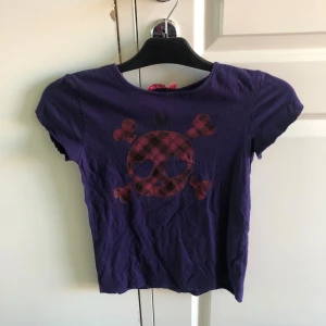 lila tshirt med döskalle😻 - jättefin tshirt med döskalle😋 jag har klippt av ärmarna så det är en rawedge  på slutet av ärmarna😓 men annars är den i bra skick. är som en storlek xs/s. tvättas före det skickas!