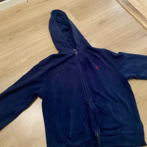 Ralph lauren zip up - Säljer min gamla Ralph lauren zip som är väldigt lite sliten. (det synns knappt) Den är storlek 170. (Det är mörkt vid logan för jag sprutade lite vatten på den, jag stryker den innan bilden togs)