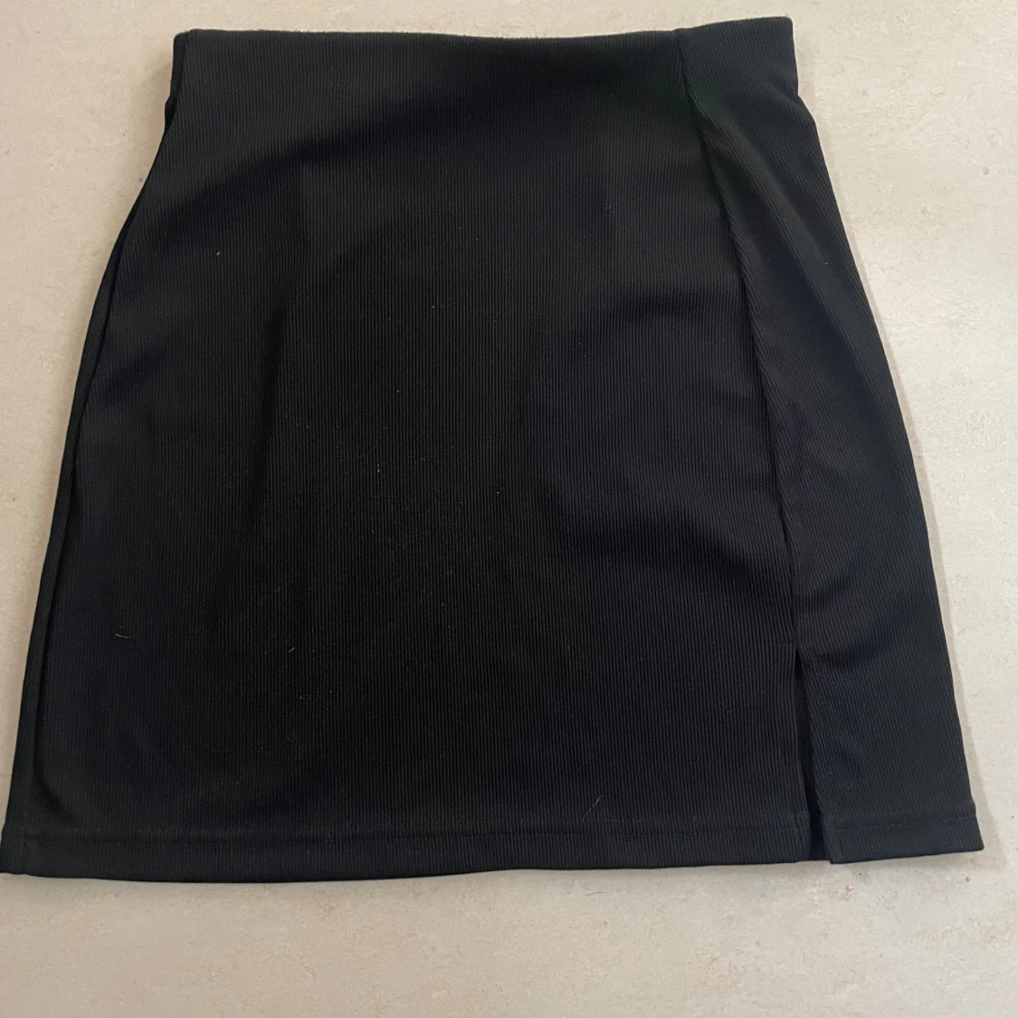 En svart ribbad kort-kjol med slits 