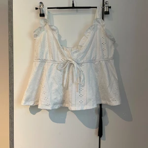 Kort vit topp - En kort vit topp som sällan används i storlek S men går att justera så den passar även för M också.