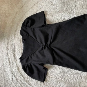 Svart topp - Svart v-ringad topp, Svalt tyg som inte är genomskinligt, den är bekväm, fin och modern. Använd väldigt få gånger. 