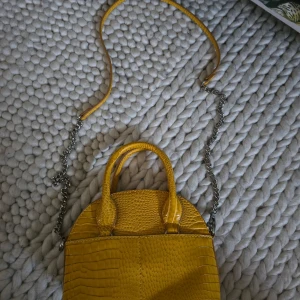 Gul väska  - Snygg gul väska med silver detaljer, ormskin imitation. Går att användas som crossbody eller minibag! (Kedjan går att tas av) Aldrig använts. Köptes från Zara! Pris kan förhandlas!