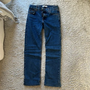 Blå jeans från Pull&Bear - Säljer ett par snygga blå jeans från Pull&Bear. De är i storlek 32 och har en klassisk femficksdesign med knappar och dragkedja. De har en normal passform och är tillverkade i ett slitstarkt denim-material. Jeansen är i bra skick!💕