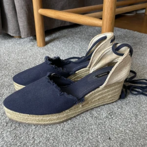 Blå kilklackssandaler från Mango - Säljer ett par snygga blå kilklackssandaler från Mango i storlek 40.